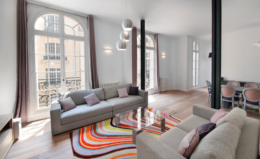 Repräsentatives, Offenes, Großes, Fernseherloses Modernes Wohnzimmer ohne Kamin mit weißer Wandfarbe und braunem Holzboden in Paris