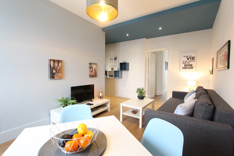 Inspiration for a medium sized scandinavian formal open plan living room in Grenoble with grey walls, light hardwood flooring, a freestanding tv and beige floors.