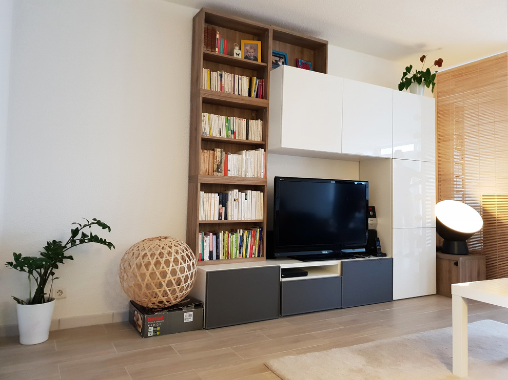 Exempel på ett litet modernt allrum med öppen planlösning, med ett bibliotek, vita väggar, klinkergolv i keramik, en fristående TV och beiget golv