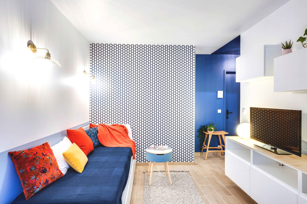 Foto de salón abierto escandinavo pequeño con paredes azules, televisor independiente y suelo de madera clara