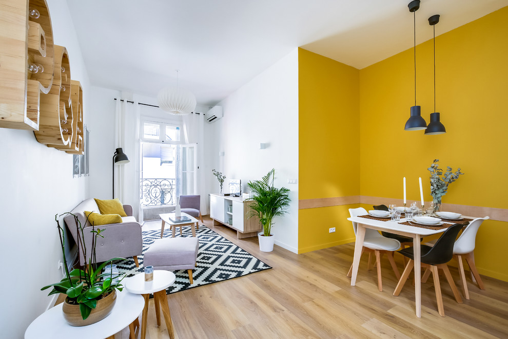 Cette image montre un grand salon nordique avec un mur jaune et un sol en vinyl.