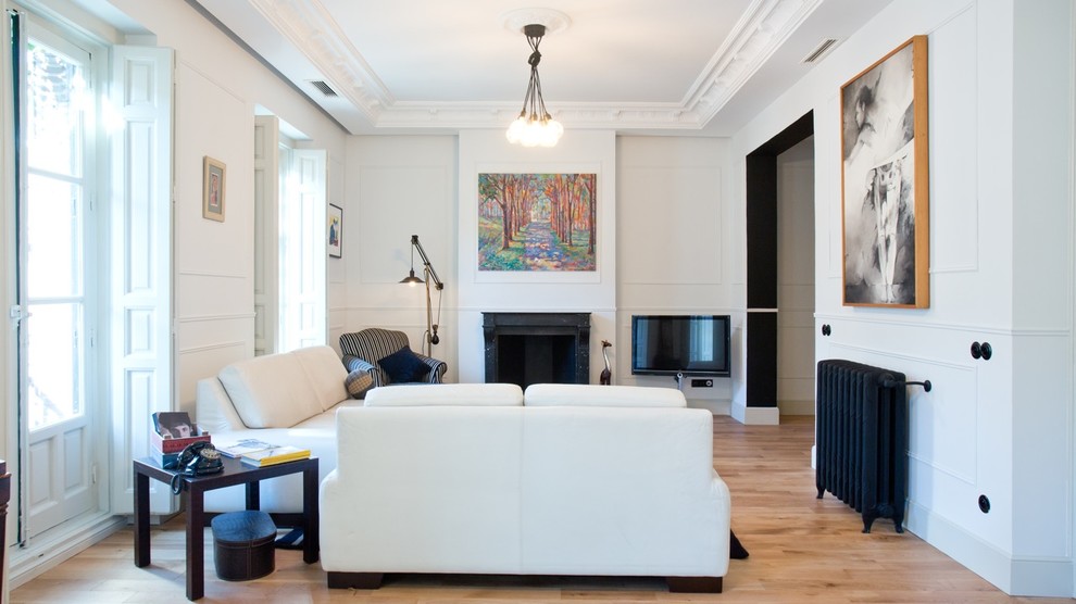 Repräsentatives, Abgetrenntes, Großes Modernes Wohnzimmer mit weißer Wandfarbe, braunem Holzboden, Kamin, TV-Wand und Kaminumrandung aus Stein in Paris