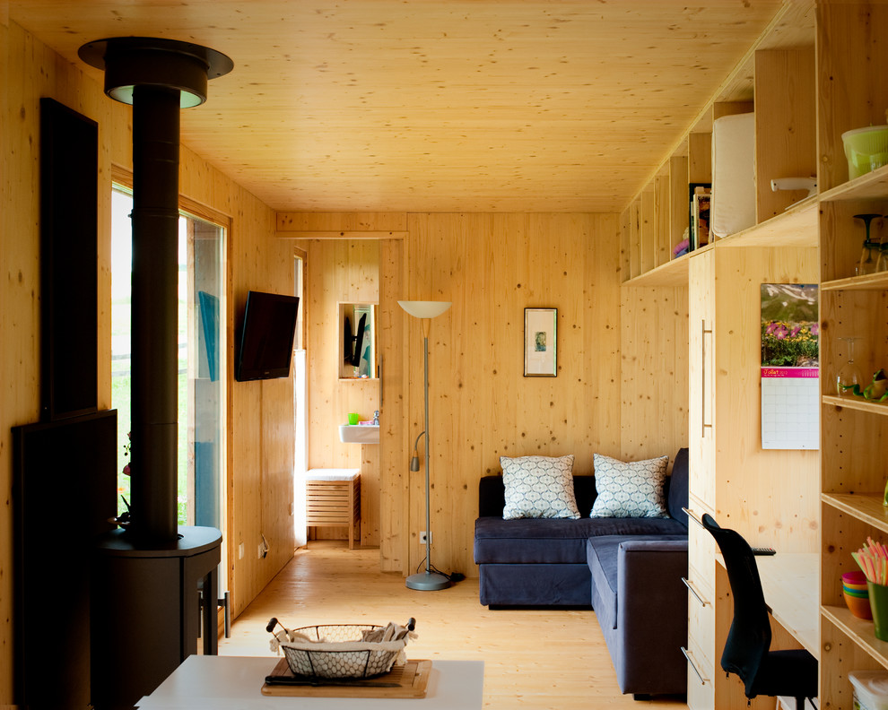 Imagen de salón abierto rústico de tamaño medio sin chimenea con paredes marrones, suelo de madera en tonos medios y televisor colgado en la pared