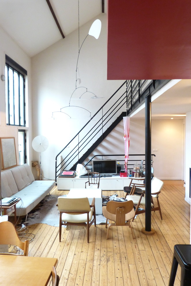 На фото: гостиная комната среднего размера в современном стиле с красными стенами, светлым паркетным полом, стандартным камином и фасадом камина из штукатурки с