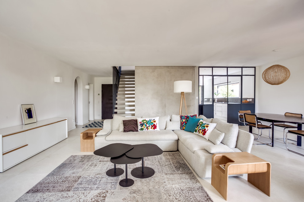 Fernseherloses, Offenes Modernes Wohnzimmer ohne Kamin mit weißer Wandfarbe und weißem Boden in Paris