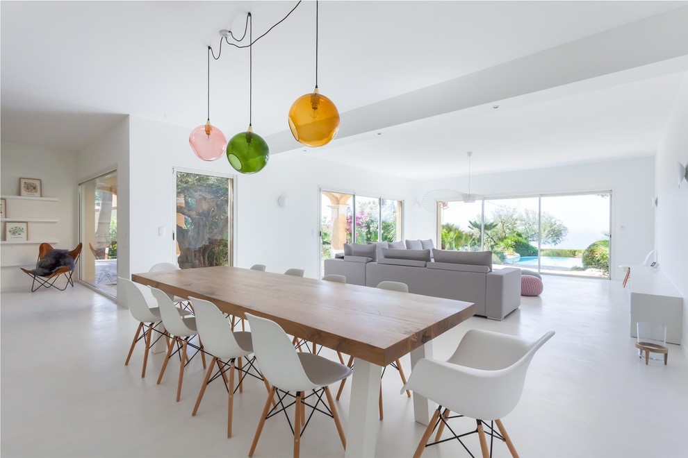 Huge danish concrete floor and white floor dining room photo in Paris with white walls