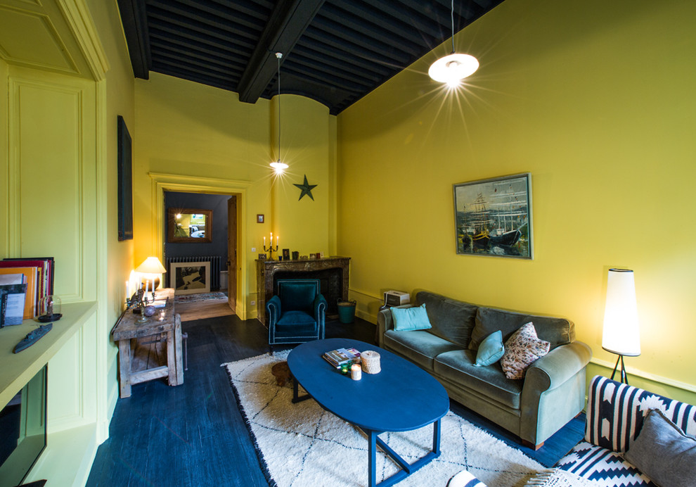 Immagine di un soggiorno boho chic chiuso e di medie dimensioni con sala formale, pareti gialle, camino classico e TV autoportante