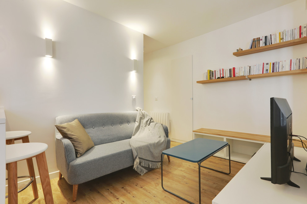 Aménagement d'un salon scandinave de taille moyenne et ouvert avec une bibliothèque ou un coin lecture, un mur blanc, un sol en vinyl et un téléviseur indépendant.