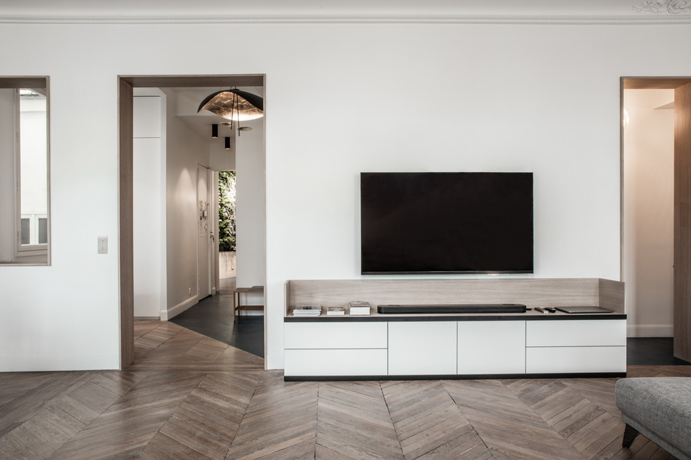 Photo of an expansive contemporary open plan living room in Paris with a music area, white walls, light hardwood flooring and a freestanding tv.