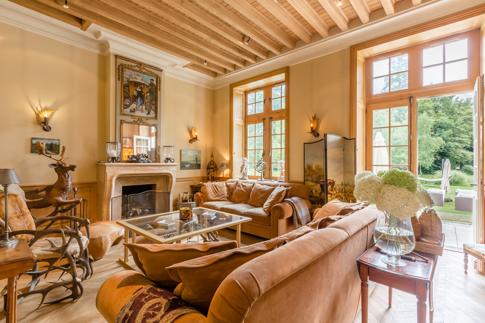 Imagen de salón clásico con paredes beige, todas las chimeneas y suelo de madera en tonos medios
