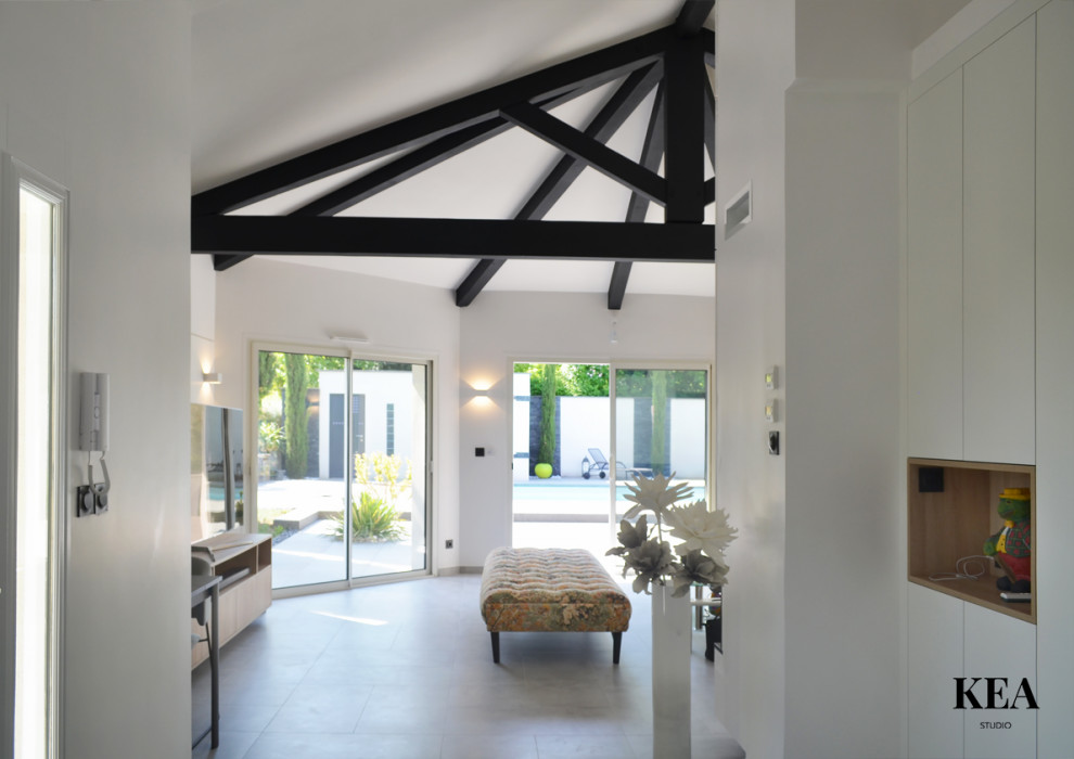 Cette image montre un grand salon design avec un mur blanc, un sol en carrelage de céramique, une cheminée standard, un manteau de cheminée en bois, un téléviseur indépendant et un sol gris.