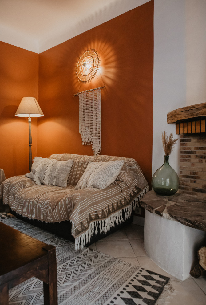 Offenes Mediterranes Wohnzimmer mit Keramikboden, Eckkamin, Kaminumrandung aus Backstein und weißem Boden in Bordeaux