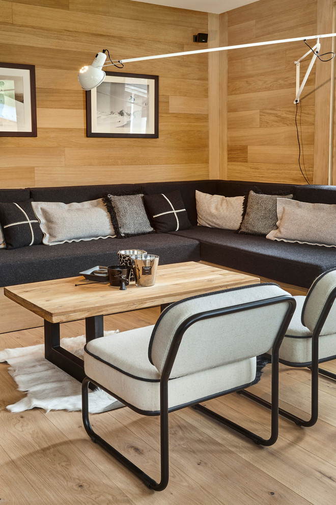 Modelo de salón abierto escandinavo de tamaño medio sin chimenea con paredes beige, suelo de madera clara y televisor colgado en la pared
