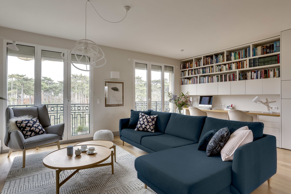Design ideas for a scandinavian open plan living room in Paris with white walls, medium hardwood flooring, a freestanding tv and brown floors.