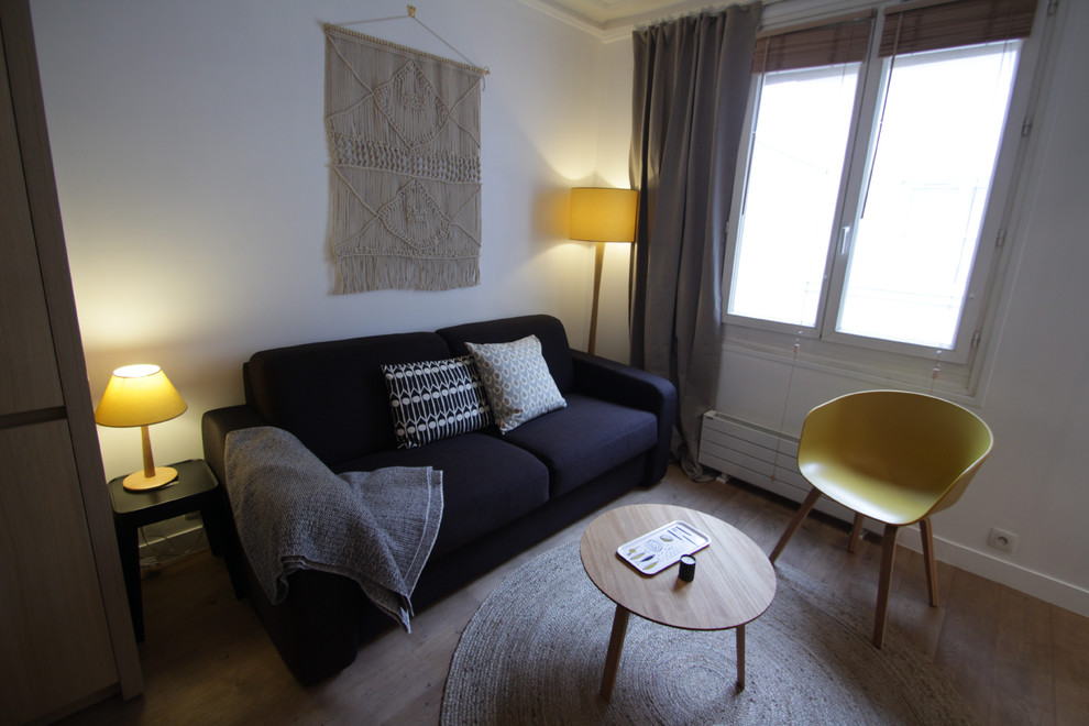 Immagine di un soggiorno nordico di medie dimensioni e aperto con pareti bianche e parquet chiaro