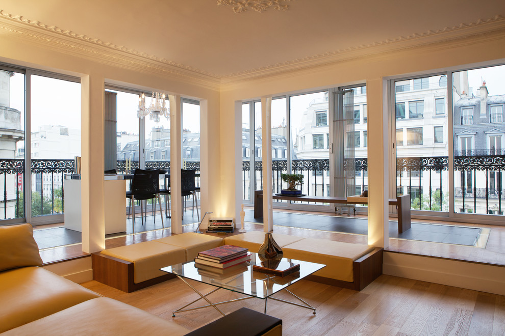 Modernes Wohnzimmer mit weißer Wandfarbe und braunem Holzboden in Paris