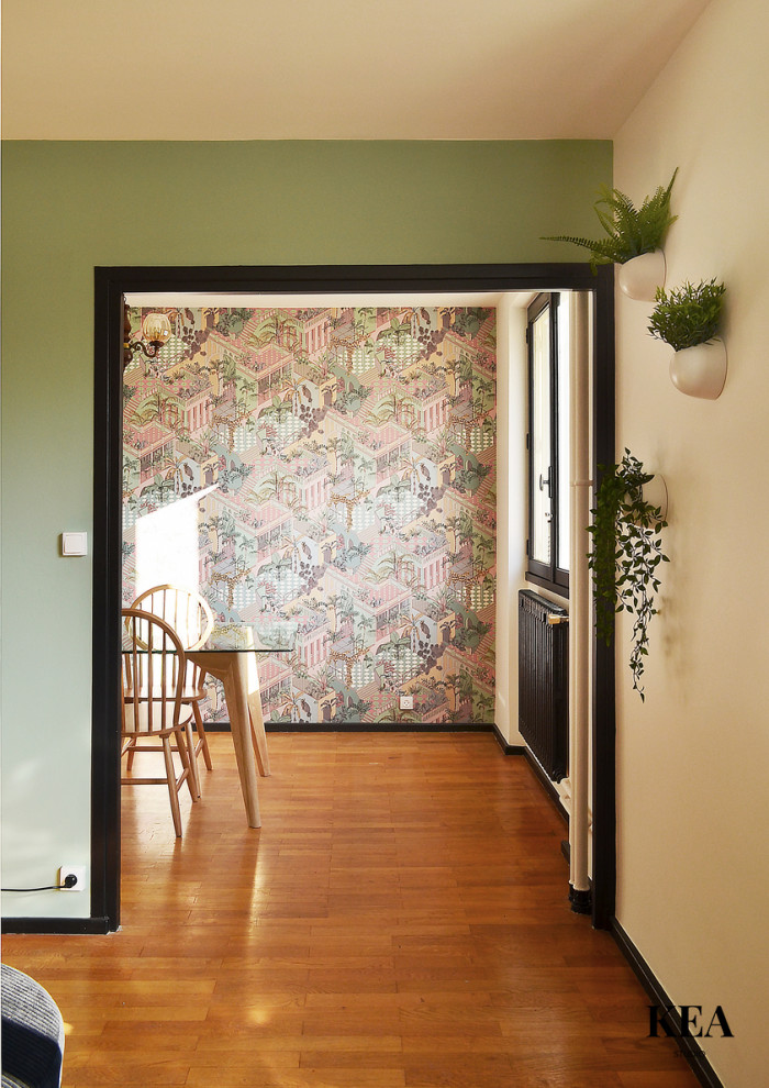 Inredning av ett modernt mellanstort vardagsrum, med gröna väggar, mellanmörkt trägolv, en fristående TV och brunt golv