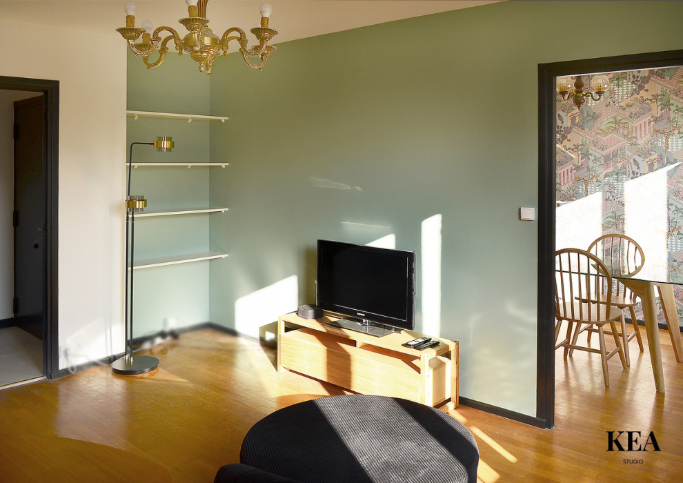 Esempio di un soggiorno design di medie dimensioni con pareti verdi, pavimento in legno massello medio, nessun camino, TV autoportante e pavimento marrone