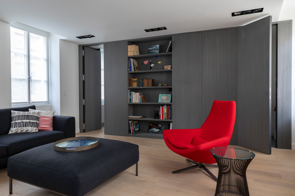 Foto di un soggiorno contemporaneo di medie dimensioni e aperto con libreria, pareti bianche, parquet chiaro, TV nascosta e pavimento beige