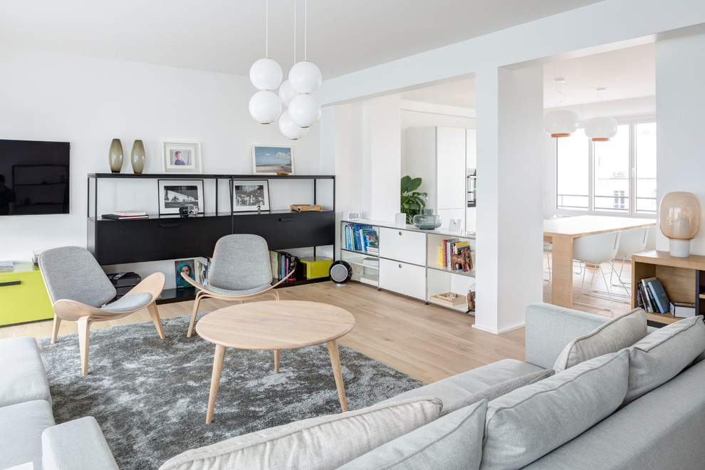 Immagine di un soggiorno scandinavo di medie dimensioni e aperto con sala formale, pareti bianche, parquet chiaro, pavimento beige, TV a parete e nessun camino
