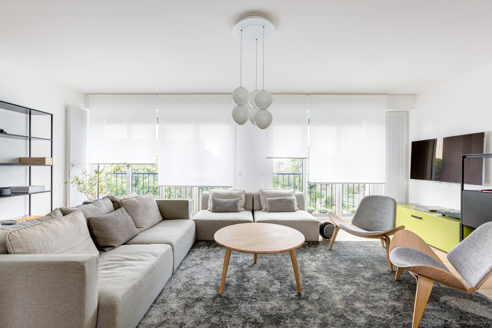 Inspiration för ett mellanstort minimalistiskt allrum med öppen planlösning, med ett finrum, vita väggar, ljust trägolv, en väggmonterad TV och beiget golv