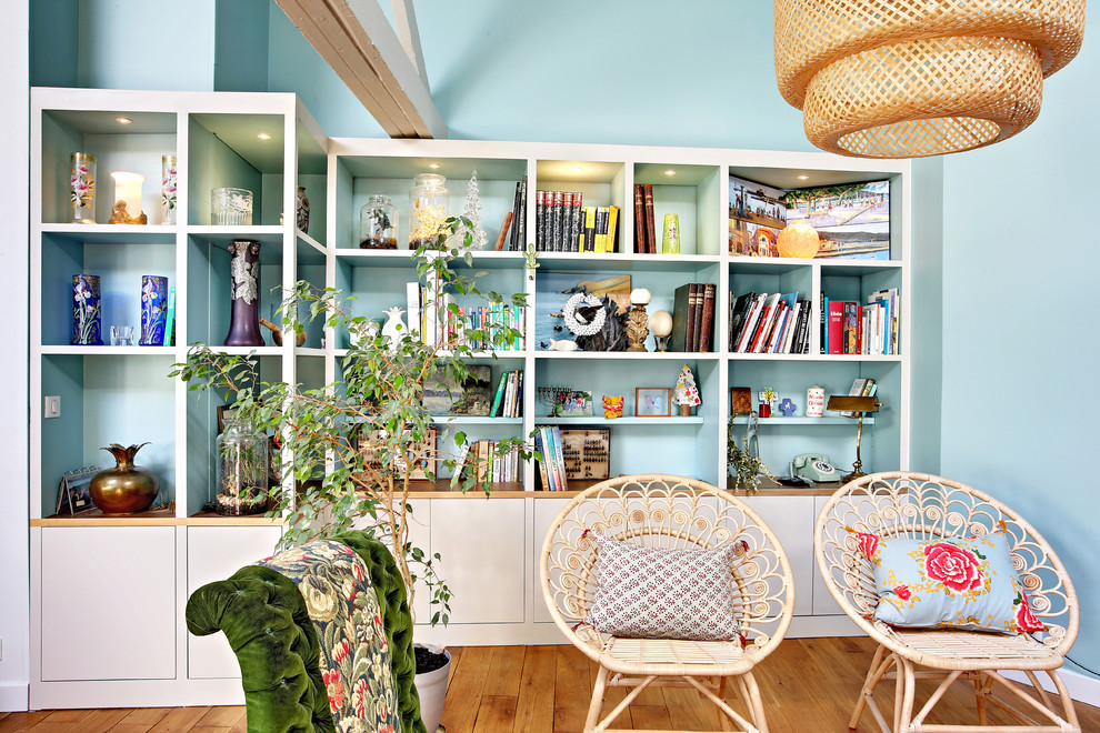 Großes, Offenes Wohnzimmer mit blauer Wandfarbe, braunem Holzboden und braunem Boden in Paris