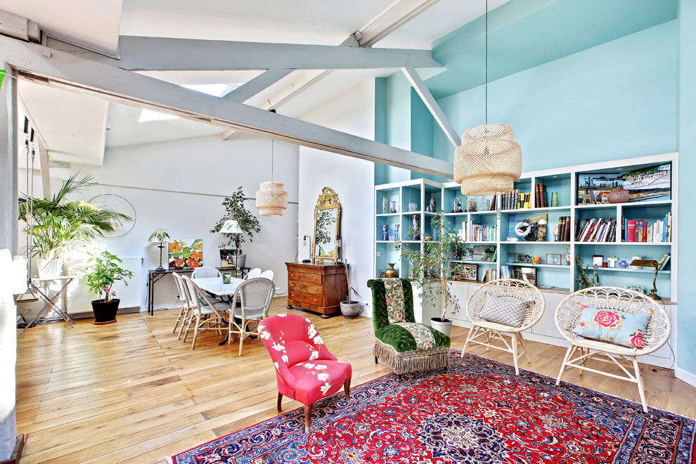 Idee per un grande soggiorno tropicale aperto con pareti blu, pavimento in legno massello medio e pavimento marrone