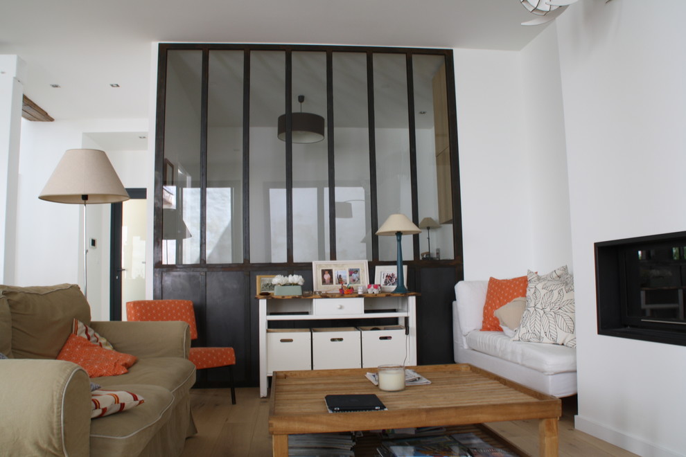 На фото: открытая гостиная комната в современном стиле с белыми стенами, светлым паркетным полом, стандартным камином и фасадом камина из штукатурки без телевизора