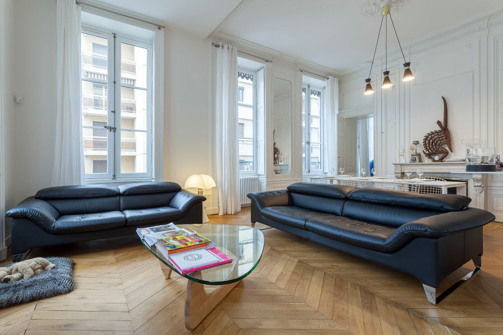 Immagine di un soggiorno design aperto e di medie dimensioni con pareti bianche, parquet chiaro e camino classico