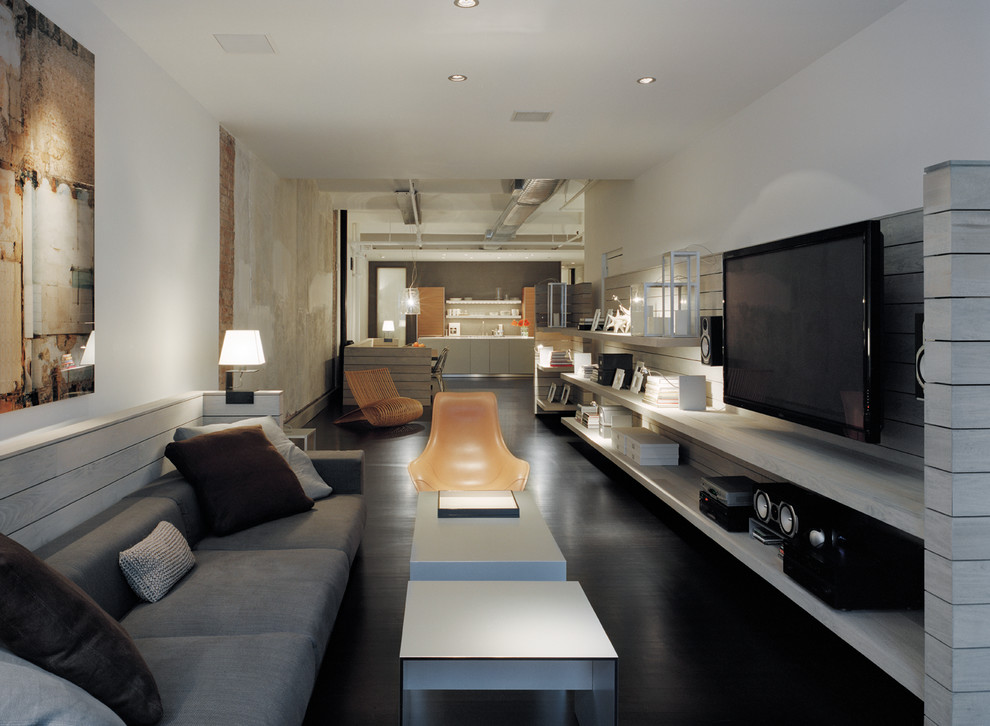 Immagine di un grande soggiorno moderno aperto con pareti bianche, parquet scuro e TV a parete