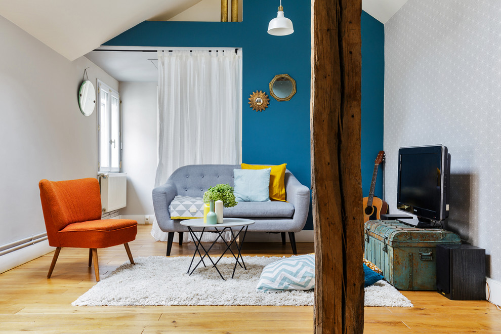 Стильный дизайн: парадная, изолированная гостиная комната в стиле фьюжн с синими стенами, светлым паркетным полом, отдельно стоящим телевизором и акцентной стеной - последний тренд