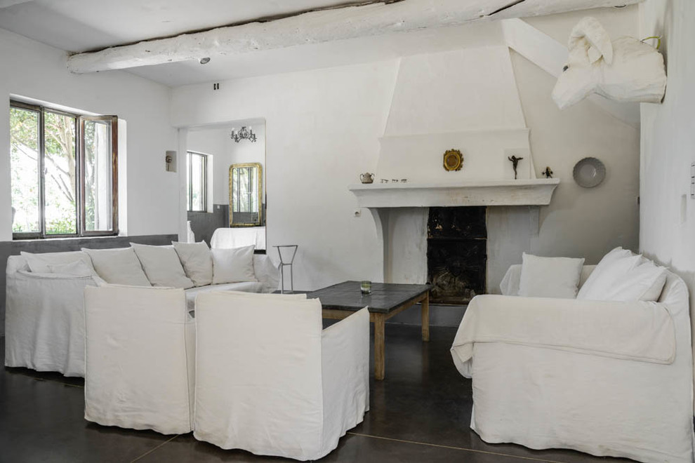 Свежая идея для дизайна: гостиная комната среднего размера в средиземноморском стиле с белыми стенами, стандартным камином и фасадом камина из бетона - отличное фото интерьера