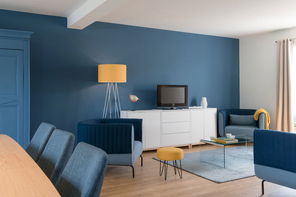 Foto de salón abierto escandinavo grande sin chimenea con paredes azules y suelo de madera clara