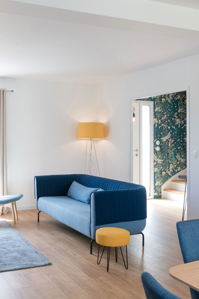 Imagen de salón abierto escandinavo grande sin chimenea con paredes azules y suelo de madera clara