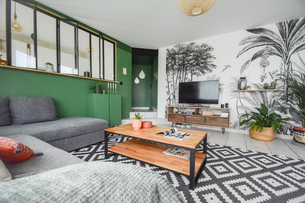 Inredning av ett modernt allrum med öppen planlösning, med gröna väggar, en fristående TV och beiget golv