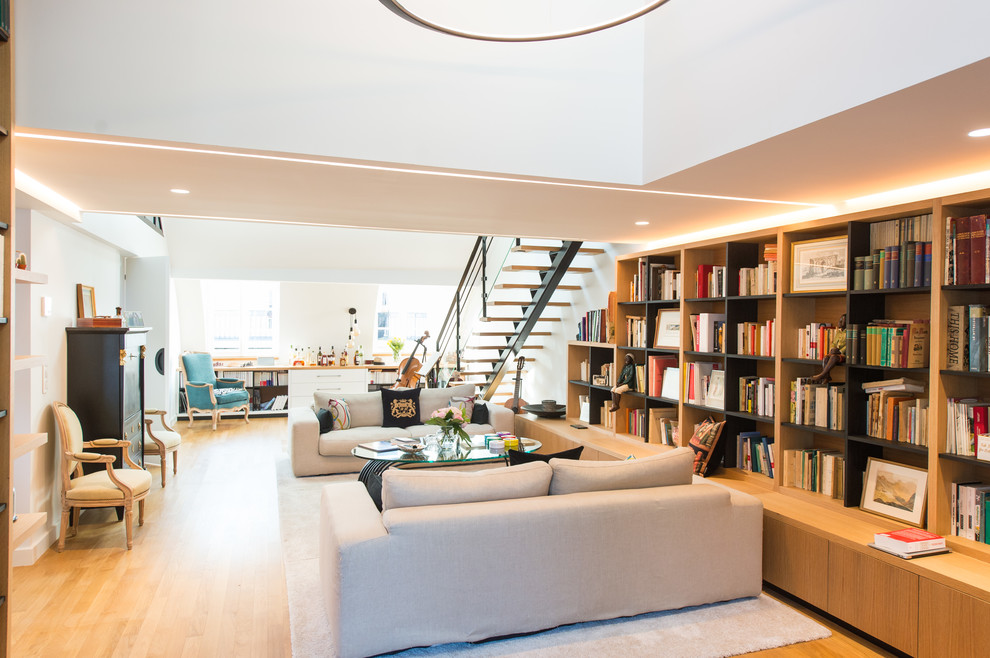 Foto de biblioteca en casa abierta tradicional grande sin chimenea y televisor con paredes blancas, suelo de madera clara y suelo beige