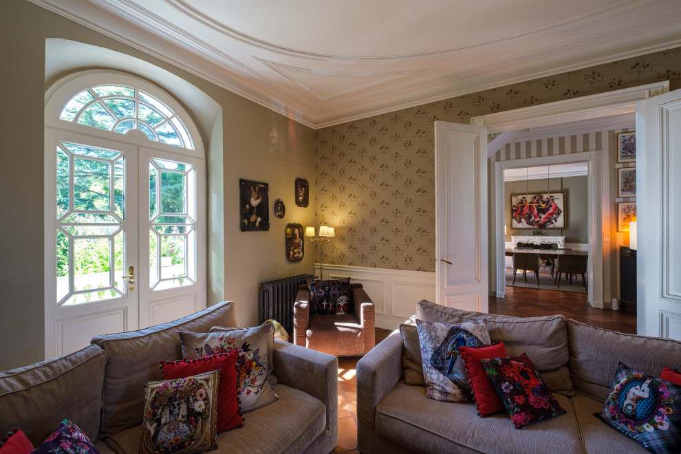 Immagine di un grande soggiorno tradizionale chiuso con libreria, pareti beige, pavimento in terracotta, camino classico, pavimento rosso, soffitto ribassato e carta da parati