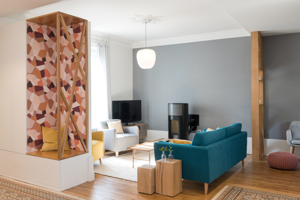 Inspiration pour un salon design ouvert avec un mur gris, un sol en bois brun, un téléviseur indépendant et un sol marron.