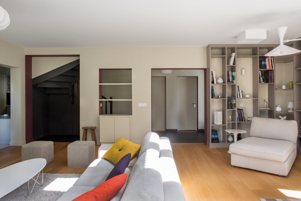 Photo of a scandinavian open plan living room in Paris with a reading nook, beige walls, light hardwood flooring and brown floors.