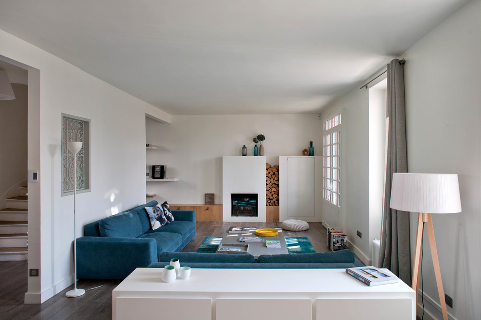 Großes, Fernseherloses, Abgetrenntes Modernes Wohnzimmer mit weißer Wandfarbe, dunklem Holzboden und Kamin in Paris