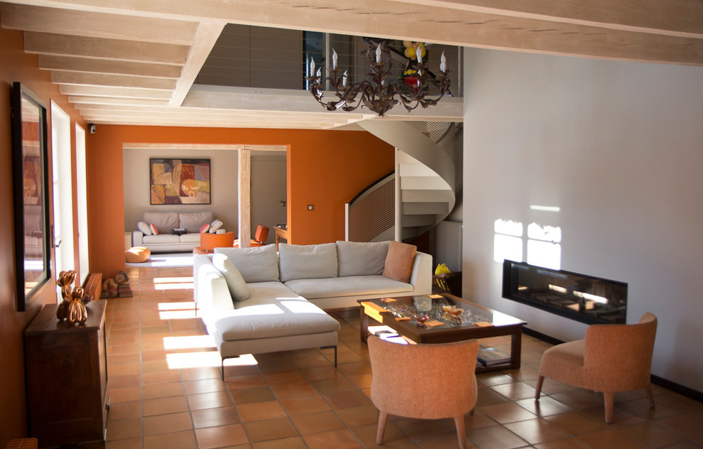 Ispirazione per un grande soggiorno minimal stile loft con pareti bianche, pavimento in terracotta, camino lineare Ribbon, cornice del camino in intonaco e pavimento arancione