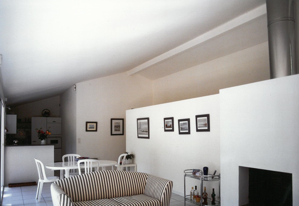 Idée de décoration pour un petit salon design ouvert avec un bar de salon, un mur blanc, un sol en carrelage de céramique, une cheminée standard, un manteau de cheminée en plâtre, un téléviseur dissimulé et un sol marron.