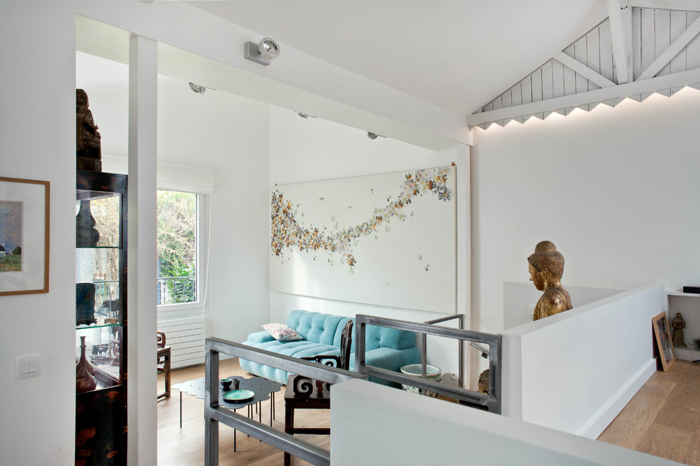 This is an example of a bohemian open plan living room in Paris with white walls, medium hardwood flooring, brown floors and exposed beams.