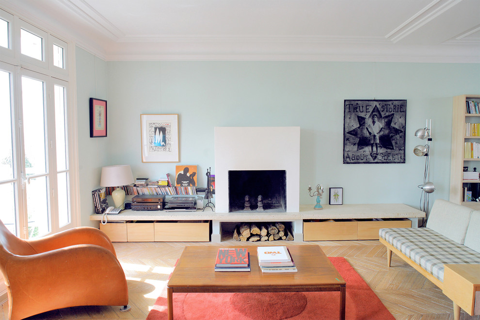 Diseño de salón actual grande sin televisor con paredes azules, suelo de madera clara, todas las chimeneas, marco de chimenea de hormigón y suelo beige