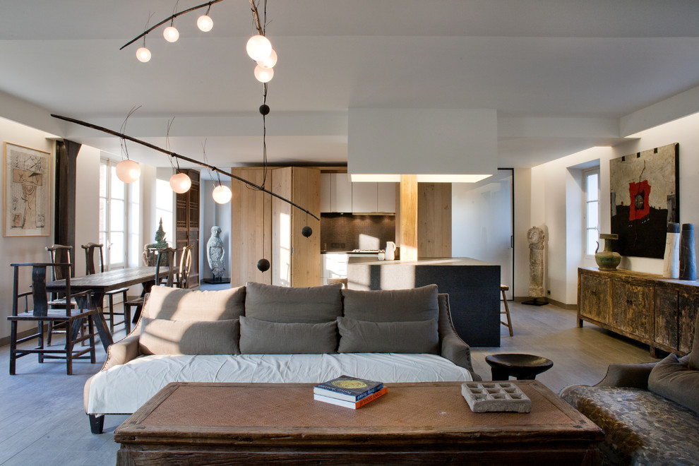 Стильный дизайн: открытая гостиная комната в стиле фьюжн с белыми стенами, полом из ламината, стандартным камином, серым полом и многоуровневым потолком - последний тренд