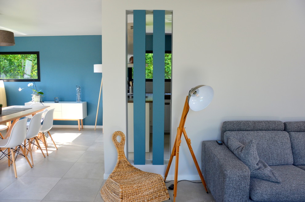 This is an example of a large contemporary mezzanine living room in Nantes with blue walls, ceramic flooring, no fireplace and a built-in media unit.