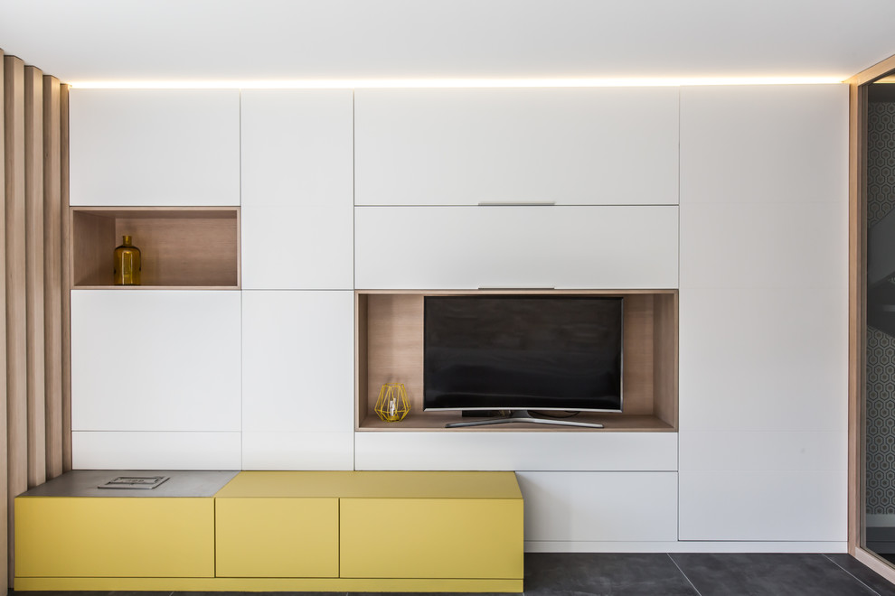 Immagine di un soggiorno minimal di medie dimensioni e aperto con angolo bar, pavimento con piastrelle in ceramica, pavimento grigio, pareti gialle e TV autoportante
