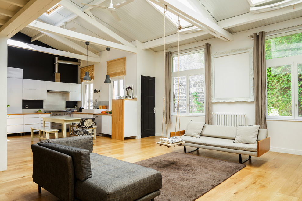Offenes Industrial Wohnzimmer mit weißer Wandfarbe und hellem Holzboden in Paris