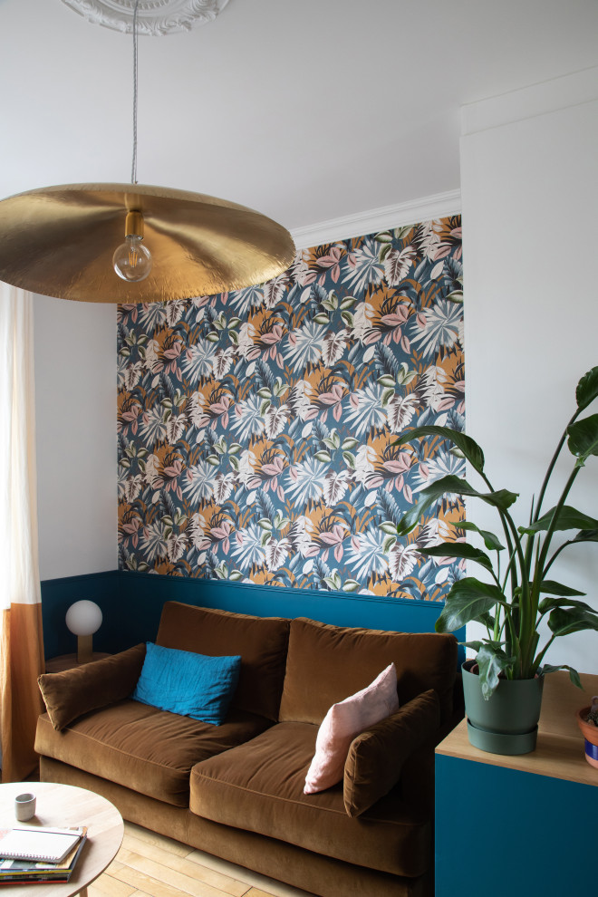 Mittelgroßes, Offenes Modernes Wohnzimmer mit blauer Wandfarbe, hellem Holzboden, Kaminofen, Kaminumrandung aus Metall, TV-Wand und beigem Boden in Paris
