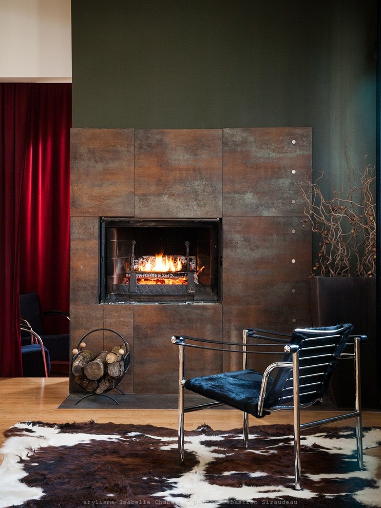 Diseño de salón para visitas abierto contemporáneo de tamaño medio sin televisor con paredes verdes, suelo de madera clara, marco de chimenea de metal y todas las chimeneas